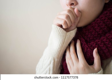 Young ill female have a cough and sore throat in winter. Causes of cough include common cold, flu, respiratory tract infection, pneumonia, bronchitis, allergy, asthma or COPD. Copy space. Health care.
