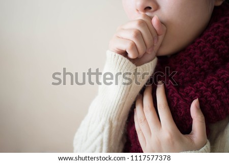 Young ill female have a cough and sore throat in winter. Causes of cough include common cold, flu, respiratory tract infection, pneumonia, bronchitis, allergy, asthma or COPD. Copy space. Health care.