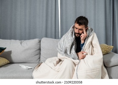 Young Ill Man Coming Early From The Work To Home Feeling Sick And Exhausted. Drunk Male Sitting On Sofa Feeling Hangover After Last Night Party.