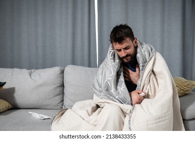 Young Ill Man Coming Early From The Work To Home Feeling Sick And Exhausted. Drunk Male Sitting On Sofa Feeling Hangover After Last Night Party.