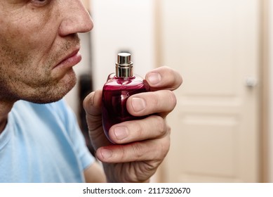 Young ill man trying to sense smell of perfume