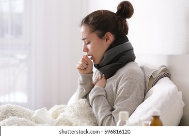 Young ill woman in bed at home - Shutterstock ID 596816120