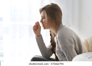 Young Ill Woman Sitting On Lounge At Home