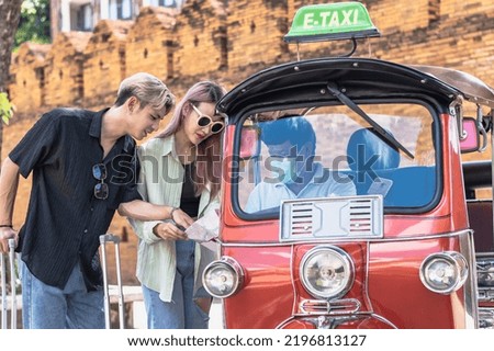 Young independent hipster Asian traveller man and woman asking  hotel direction from local tuk tuk taxi at Tha Pae Gate, Chiang Mai, tuktuk Thailand and happy holidays  concept