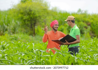 Young India Bank Officer Completing Paper Work With Farmers At Agriculture Field.