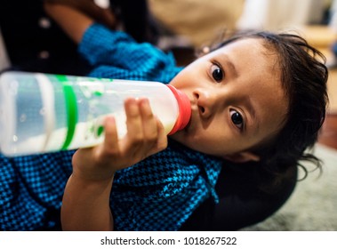 Young Indian Boy Drinking Milk From Bottle