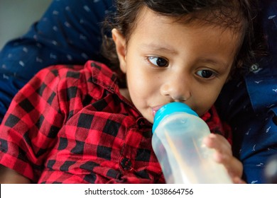 Young Indian Boy Drinking Milk From Bottle