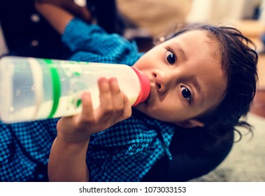 Young Indian Boy Drinking Milk From Bottle