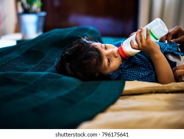 Young Indian Boy Drinking Milk From Bottle