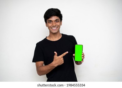 Young indian boy holding a mobile phone and point towards it's screen. Mobile phone with a green screen for mockup. - Powered by Shutterstock