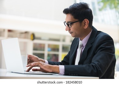 Young Indian Business Man On Laptop And Coffee At A Cafe