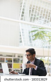 Young Indian Business Man On Laptop And Coffee At A Cafe 