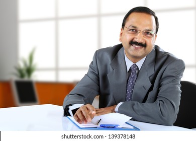 Young Indian Business Man Sitting At His Desk