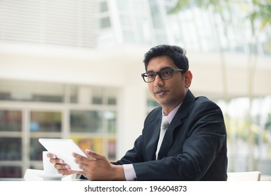 Young Indian Business Man With A Tablet Computer And Coffee At A Cafe