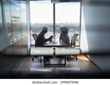 Young Indian Businessman Ceo Hr Director Having Interview Hiring For Job With Female African American Attorney Sitting In Office At Panoramic View Window. Shot Through Jalousie Glass.