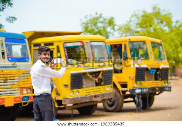 Young indian businessman with his freight forward\
lorry or truck.