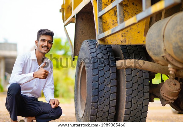 Young indian businessman with his freight forward\
lorry or truck.