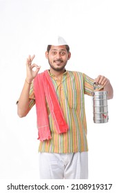 Young Indian Common Man In Traditional Wear Holding Tiffin Box In Hand On White Background.