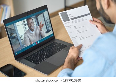 Young Indian Confident Businessman Holding Cv Talking To Male Black Man Potential Employee Hiring For Job. Virtual Video Call Between Employer And Manager Worker. Remote Recruitment Work Concept.