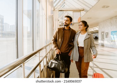 Young indian couple looking in window together at airport indoors - Shutterstock ID 2160065037