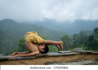 A Young Indian Cute Kid Doing Yoga In The Mountains,wearing A Dhoti
