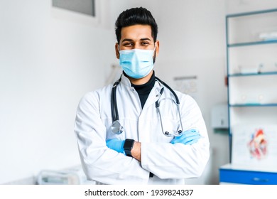 A Young Indian Doctor In A Protective Mask And Gloves With A Stethoscope On Among A Modern Hospital, Indian Medicine, Health And Self-care.