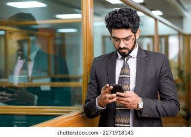 Young indian entrepreneur using smartphone at office - Powered by Shutterstock