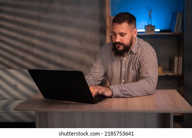 Young Indian Ethnic Businessman Developer Or Web Designer Typing On Laptop Distance Working Online Late At Night At Home Using Laptop Sitting At Workplace.