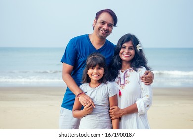 Young Indian Family Relaxing At The Beach On Beautiful Summer Day In Goa