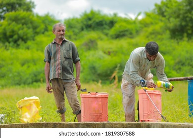 young indian farmer with spray pump and pesticide