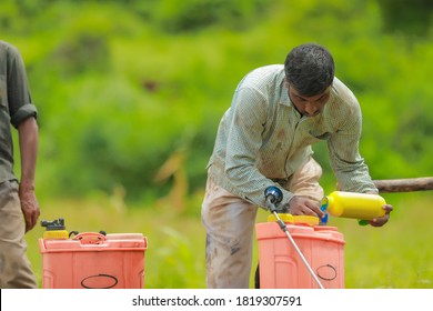 young indian farmer with spray pump and pesticide