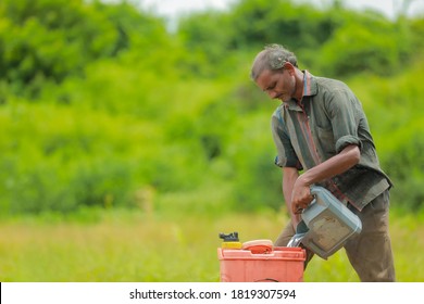 young indian farmer with spray pump and pesticide