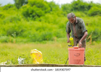 young indian farmer with spray pump and pesticide