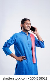 Young Indian Farmer Talking On Mobile Phone Over White Background.