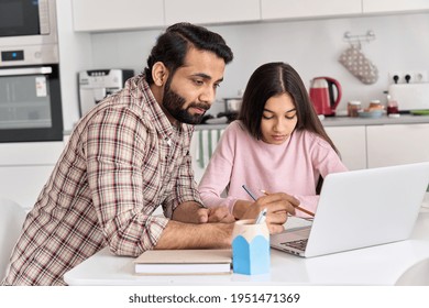 Young indian father helping school child teen daughter studying online at home. Dad and kid girl elearning having virtual class on laptop, studying remote homeschool lesson on computer together.