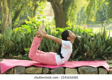 Young Indian Female Child Practicing  Yoga In The Park In Day Time. Girl Is Doing Yoga In Clean And Green Environment And Fresh Air.