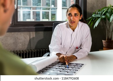 Young Indian Female Doctor Discussing CT Scans With A Female Patient. Medium Shot. 