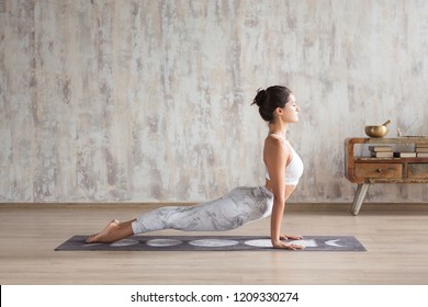 Young Indian Girl Doing Yoga Fitness Exercise Indoor. Wellness Concept. Calmness And Relax. Yogi Instructor Doing Urdhva Mukha Shvanasana Exercise, Upward Facing Dog Pose, Working Out, Home Interior