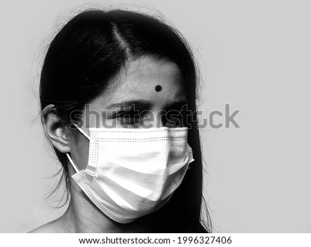 young indian girl with mask to protect herself from corona virus with black and white effect