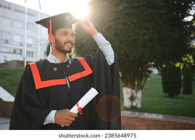 Young indian graduated boy holding his graduation degree convocation ceremony. student graduate posing - Powered by Shutterstock