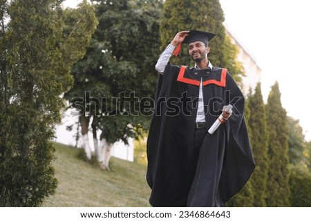 Young indian graduated boy holding his graduation degree convocation ceremony. student graduate posing