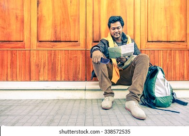 Young Indian Guy Looking City Map Holding Mobile Phone - Asian Model Male Next To Old Wooden Door - Cheerful Afro American Student Reading - Concept Of Tourism DIY And Freedom - Soft Vintage Filter