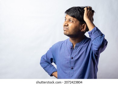 A Young Indian Male In Blue Dress Scratching Head And Thinking On White Background