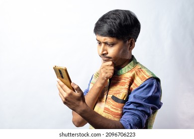 A Young Indian Male In Blue Dress With Thoughtful Face Holding Smart Phone On White Background