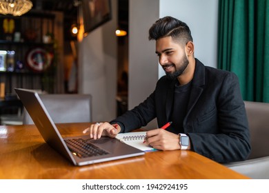 Young Indian Male Working On Laptop At Cafe Shop