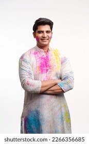 Young Indian man celebrating holi festival and giving expression on white background.