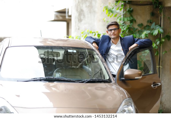 Young indian man with his\
car