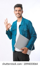 Young Indian Man Holding Laptop In Hand On White Background.