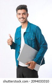 Young Indian Man Holding Laptop In Hand On White Background.