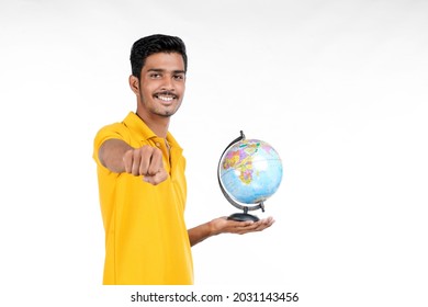 Young indian man holding palms Earth world globe in hand